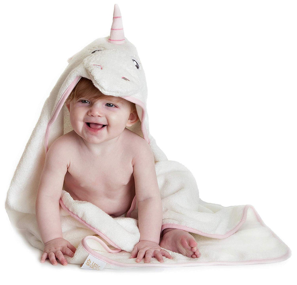 Alt = Baby sitting wearing Pink Unicorn hooded towel looking sideways